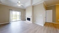 Located in Fort Worth, TX, this well-appointed 3-bedroom, 2-bathroom residence offers a thoughtfully designed single-floor layout that balances comfort and functionality. The living area serves as the heart of the home, highlighted by a classic tiled fireplace, a raised tray ceiling with a ceiling fan, and a sliding glass door that opens to a private balcony with open outdoor views. Wood-look flooring flows throughout the main living areas, complemented by warm neutral tones and crisp crown molding throughout.

The galley-style kitchen is efficiently laid out with white cabinetry, subway tile backsplash, stainless steel appliances including a refrigerator, range, and microwave, and ample counter space for meal preparation. A hallway connects the kitchen to the living areas and bedroom wing.

All three bedrooms feature plush carpeting, ceiling fans, and crown molding. The primary bedroom includes a walk-in closet and a window offering natural light. Each bedroom provides a calm, comfortable retreat. The two full bathrooms are finished with wood-look flooring, white cabinetry with brushed nickel hardware, and a tub-shower combination. Three closets throughout the unit provide generous storage options.