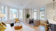 Located on Philadelphia's iconic Avenue of the Arts, this thoughtfully designed 2-bedroom, 2-bathroom residence offers a seamless blend of classic architectural character and contemporary finishes. The open-concept kitchen and living area serves as the heart of the home, where large double-hung windows frame sweeping city skyline views and flood the space with natural light. Light-toned hardwood floors run throughout, complementing the airy, neutral palette. The kitchen is appointed with quartz countertops featuring elegant veining, white shaker cabinetry, stainless steel appliances, and a standout brass faucet that adds a warm, sophisticated accent. The living area provides generous space for both lounging and dining beneath recessed lighting. The primary bedroom is a serene retreat with tall ceilings, wide windows with city outlooks, and a calm, warm color palette. The second bedroom is equally inviting, offering ample storage with built-in wardrobe units and street-facing windows. The hallway, clad in textured slate-toned wallcovering, adds a refined touch and houses a conveniently tucked-away stacked in-unit washer and dryer. Both bathrooms are tastefully finished, with one featuring basket-weave tile flooring, a fluted wood vanity, and matte black fixtures. This residence delivers urban sophistication in one of Philadelphia's most vibrant cultural corridors.