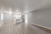 Located at 1229 Pacific Ave in Santa Rosa, California, this 2-bedroom, 1-bathroom residence offers a thoughtfully arranged single-floor layout designed for comfortable everyday living. The open-concept main living area seamlessly connects the living room, dining space, and kitchen, all unified by light gray walls and durable wood-style vinyl flooring that runs throughout the common areas. Large windows with vertical blinds invite natural light into the living room, which also features a wall-mounted HVAC unit for year-round climate control.

The kitchen is well-appointed with crisp white cabinetry, a granite-style countertop, a double-basin sink, a white electric range, and a stainless steel refrigerator. A peninsula counter provides additional workspace and serves as a natural divider between the kitchen and living areas. Ceiling fans are present in multiple rooms, adding both function and a finishing touch.

Both bedrooms are carpeted and generously sized, each with a ceiling fan and dedicated closet space. Natural light filters in through horizontal windows, and the primary bedroom features a ceiling fan with a light fixture. The bathroom is bright and clean, showcasing white subway tile in the tub/shower surround, a vanity with a stone-style countertop, and wood-look flooring. A connecting hallway provides easy access to all rooms.