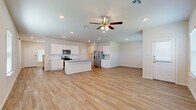 Located at 14230 James River Ridge in San Antonio, TX, this two-story home offers four bedrooms and four bathrooms thoughtfully distributed across two well-proportioned floors. The main level sets a welcoming tone with an open-concept layout that seamlessly connects the kitchen, dining, and living areas, all finished with light wood-look flooring and ceiling fans throughout. The kitchen is a standout feature, boasting crisp white shaker cabinetry, a classic subway tile backsplash, granite countertops, stainless steel appliances including a gas range, microwave, and French door refrigerator, and a central island with a sink — ideal for both cooking and casual dining. A convenient half bath with a pedestal sink serves the main floor. A staircase with wood-toned steps and a white balustrade leads to the upper level, where the four bedrooms are located. The generously sized primary bedroom includes a walk-in closet with built-in shelving. Additional bedrooms are well-sized with their own closets and ceiling fans, offering ample natural light from multiple windows. The home also includes a pantry, laundry room, patio, and an attached two-car garage with an automatic opener, completing this functional and move-in-ready residence.