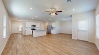 Located at 14230 James River Ridge in San Antonio, TX, this two-story home offers four bedrooms and four bathrooms thoughtfully distributed across two well-proportioned floors. The main level sets a welcoming tone with an open-concept layout that seamlessly connects the kitchen, dining, and living areas, all finished with light wood-look flooring and ceiling fans throughout. The kitchen is a standout feature, boasting crisp white shaker cabinetry, a classic subway tile backsplash, granite countertops, stainless steel appliances including a gas range, microwave, and French door refrigerator, and a central island with a sink — ideal for both cooking and casual dining. A convenient half bath with a pedestal sink serves the main floor. A staircase with wood-toned steps and a white balustrade leads to the upper level, where the four bedrooms are located. The generously sized primary bedroom includes a walk-in closet with built-in shelving. Additional bedrooms are well-sized with their own closets and ceiling fans, offering ample natural light from multiple windows. The home also includes a pantry, laundry room, patio, and an attached two-car garage with an automatic opener, completing this functional and move-in-ready residence.