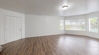 Located in Riverton, Utah, this three-story home offers eight bedrooms and four bathrooms across a well-distributed layout spanning three floors. The main level serves as the central hub, housing a combined kitchen and living area alongside a formal entrance. The kitchen is a standout feature, equipped with rich dark-wood cabinetry, white countertops, stainless steel appliances including a range, microwave, and refrigerator, and a skylight that draws in abundant natural light. A peninsula provides additional workspace and casual dining. The adjoining living area features wood-style flooring and large windows that allow natural light to fill the space.

Upper and lower floors accommodate the eight bedrooms, including a generously sized primary bedroom. Bedrooms are finished with neutral carpet, white walls, and standard closets. The four bathrooms are consistently finished with earth-toned tile flooring, white tub-shower combinations, and wood-cabinet vanities with dark countertops. A dedicated laundry room houses a full-size washer and dryer with overhead shelving. Hallways and staircases connect all three levels efficiently, making this home well-suited for large households.