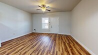 Located at 100 Fieldstone Ln in Monroe, Louisiana, this single-story, one-bedroom, one-bathroom home offers a practical and comfortable layout with consistent wood-look flooring flowing throughout every room. The living room serves as the welcoming heart of the home, featuring a ceiling fan with light fixture, a front-facing window that brings in natural light, and a classic paneled entry door. Neutral-toned walls and clean white baseboards create a bright, open atmosphere. The kitchen and living area share an open-concept arrangement, with the kitchen showcasing light wood cabinetry, a tiled backsplash, white appliances including a refrigerator, range, dishwasher, and microwave, as well as ample counter space and storage. A pendant light and overhead fluorescent fixture provide functional task lighting. The spacious bedroom includes a ceiling fan, a window for natural light, and access to two closets, offering generous storage. The full bathroom is well-appointed with a single-sink vanity featuring light wood cabinetry and stone-look countertops, a tub/shower combo, and matching wood-look flooring that ties the space together. Throughout the home, the consistent finishes and clean design provide a cohesive, move-in-ready living environment.