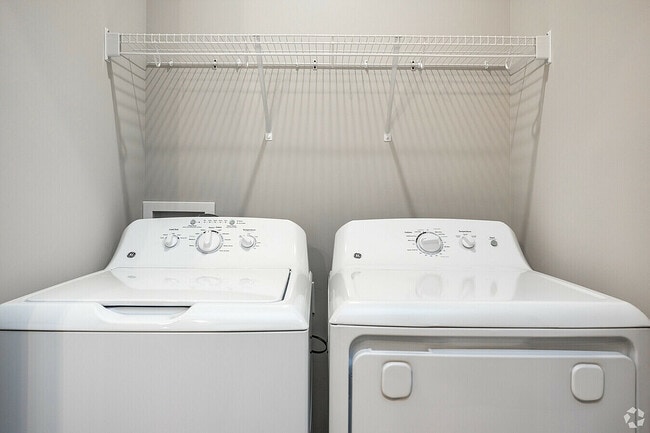 Explore this efficient laundry setup with cutting-edge appliances and ample storage. - Woodford Ridge Townhomes