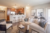 Located at 1138 Fawn Dr in Williamstown, NJ, this single-floor home offers a thoughtfully designed open-concept layout that promotes seamless flow between living spaces. The main living area features rich hardwood flooring, recessed lighting, and large windows that invite generous natural light. A bay window nook provides a cozy retreat with outdoor views, ideal as a reading or sitting area.

The kitchen is equipped with warm-toned wooden cabinetry, granite countertops, stainless steel appliances including a gas range, built-in microwave, and refrigerator, complemented by a tiled backsplash and a peninsula with bar seating. This space opens directly into the living and dining areas, making it well-suited for entertaining.

The primary bedroom is a spacious retreat with plush carpeting, a teal accent wall, and natural light from large windows. A second bedroom offers carpeted flooring, neutral tones, and a window with exterior views. Both bathrooms feature tile flooring, warm wood vanities with granite countertops, and tub-shower combinations. A dedicated laundry room includes a full-size washer and dryer alongside an on-demand water heater, adding practical convenience to this well-rounded home.