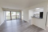 Located at 7931 Patriot Drive in Annandale, Virginia, this well-appointed three-bedroom, two-bathroom residence offers comfortable single-floor living. The open-concept living and dining area is a standout feature, showcasing light gray hardwood-style flooring, crisp white walls, and a wall of sliding glass doors that flood the space with natural light and provide direct access to a private balcony overlooking lush, tree-lined views. The kitchen is thoughtfully designed with white shaker-style cabinetry, dark granite-style countertops, a subway tile backsplash, stainless steel appliances, and a peninsula that connects seamlessly to the living area. The two bathrooms continue the modern aesthetic with white vanity cabinetry and dark countertops. The three bedrooms feature plush carpeting and individual closets, including a spacious walk-in closet with built-in shelving and hanging rods in the generously sized primary bedroom. Additional storage is provided by five closets throughout the home, including a well-shelved utility closet. A dedicated laundry room adds everyday convenience. The overall ambiance is bright, clean, and move-in ready, with a cohesive modern design throughout.