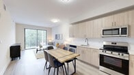 Located at 8401 NW 29th Ct in Miami, FL, this thoughtfully designed 2-bedroom, 1-bathroom residence offers a clean, modern aesthetic across a single floor. The open-concept living, dining, and kitchen area forms the heart of the home, bathed in natural light from a full sliding glass door that opens to a private outdoor space with lush greenery views. Light wood-style flooring flows seamlessly throughout, creating a cohesive and airy feel.

The kitchen is well-appointed with light birch cabinetry, white quartz countertops, a subway tile backsplash, and a full suite of stainless steel appliances including a refrigerator, range, microwave, and dishwasher. The dining area sits adjacent, offering a natural flow for everyday living and entertaining.

The primary bedroom is generously sized, featuring a bright window with outdoor views and soft, neutral tones. The second bedroom maintains the same clean design language. The shared bathroom is elegantly finished with marble-look tile flooring, an undermount sink vanity with light wood cabinetry, and a full soaking tub with shower. A hallway closet adds practical storage to this efficiently designed residence.