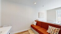 Located at 1314 Spring Garden St in Philadelphia's Spring Garden neighborhood, this one-bedroom, one-bathroom unit is thoughtfully designed to maximize every square foot. The open-concept layout seamlessly connects the living area and kitchen, creating a cohesive and functional living space. Recessed lighting and crisp white walls throughout lend a clean, modern aesthetic, while light wood-look flooring adds warmth and continuity from room to room.

The kitchen is well-appointed with stainless steel appliances — including a refrigerator, oven, and dishwasher — complemented by two-tone cabinetry in light wood and dark gray finishes, a white subway tile backsplash, and ample upper and lower storage. The living area offers a welcoming atmosphere with a large window that fills the space with natural light and frames views of the Philadelphia skyline and surrounding cityscape.

The bedroom is generously proportioned for the unit's overall footprint and features a large picture window offering expansive city views and abundant sunlight. Built-in shelving at the bedside and an integrated wardrobe maximize storage efficiency. A dedicated desk area supports a productive home environment.

The bathroom is finished in light neutral tiles, offering a clean and serene retreat with a shower/tub combination. A narrow entry hallway with glass-paneled doors leads smoothly into the main living space, contributing to the unit's polished, contemporary character.