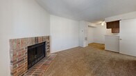 Located in Mission, Kansas, this two-story, one-bedroom, two-bathroom home offers a practical and comfortable layout spread across two floors. The main level features an open-concept living room and kitchen area, where warm-toned carpet flows throughout the living space. A classic brick fireplace serves as the focal point of the living room, adding character and charm to the otherwise clean, white-walled interior. A window invites natural light, enhancing the bright and airy feel of the space. The kitchen is appointed with rich wood cabinetry, light-toned countertops, a double-basin sink, and black appliances, all set atop durable tile flooring. A dedicated laundry room on this level features built-in shelving and tile flooring, adding everyday convenience. The upper floor houses the spacious primary bedroom, which benefits from natural light through a window and includes a closet with louvered doors. Two bathrooms — one on each floor — feature tile flooring, wood-toned vanities with ample storage, and clean white countertops. Throughout the home, textured ceilings and consistent finishes create a cohesive, functional living environment well-suited for comfortable daily living.