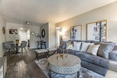 Located at 3896 Chippewa Road in Memphis, TN, this thoughtfully laid-out 2-bedroom, 1-bathroom single-floor home offers a comfortable and stylish living experience. The open living and dining area serves as the heart of the home, featuring rich wood-style flooring, neutral toned walls, and a textured ceiling. A large window dressed with patterned curtains fills the space with natural light, while a defined dining area provides ample room for everyday living and entertaining. The galley-style kitchen is equipped with white cabinetry, dark granite-style countertops, and black appliances including a refrigerator and electric range, offering a functional and clean workspace. A hallway connects the main living areas to the two bedrooms and shared bathroom. The spacious primary bedroom features a large window with vertical blinds and drapes, dark hardwood-style flooring, and a relaxed, neutral palette. The second bedroom is bright and versatile, also benefiting from natural light through a generous window. The full bathroom includes a tub-shower combination with tile surround, a decorative shower curtain, and wood-style flooring, maintaining a consistent design throughout the home.
