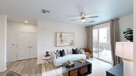 This thoughtfully designed one-bedroom, one-bathroom unit offers a functional and contemporary single-floor layout. The open-concept kitchen is a standout feature, outfitted with light wood-grain cabinetry extending to the ceiling, white quartz countertops, a subway tile backsplash, stainless steel appliances including a refrigerator, range, and built-in microwave, and a peninsula with pendant lighting that provides additional prep and dining space.

The living room features wood-style flooring, a ceiling fan with integrated lighting, and a sliding glass door that opens to a private outdoor patio, filling the space with natural light. The bedroom is carpeted and comfortably sized, equipped with its own ceiling fan, a large window with outdoor views, and direct access to a dedicated walk-in closet. The bathroom includes a wide, floating wood-grain vanity with quartz countertops, a large mirror with overhead lighting, wood-look tile flooring, and a shower-tub combination. Throughout the unit, a neutral white and warm wood palette contributes to a clean, modern aesthetic.