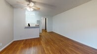 Located at 11901 176th St in Artesia, California, this single-floor unit offers a straightforward and functional layout designed for comfortable everyday living. Throughout the space, rich hardwood flooring adds warmth and continuity, tying each area together seamlessly.

The open living area is generously proportioned, bathed in natural light through a large window dressed with vertical blinds. A ceiling fan overhead provides year-round comfort, while a wall-mounted air conditioning unit ensures efficient climate control. The clean white walls and textured ceiling contribute to a bright, neutral ambiance that's easy to personalize.

A half-wall pass-through connects the living space to the kitchen area, which features white cabinetry and a light countertop, offering both practicality and an open feel. A hallway leads from the main living space to the rest of the unit, providing a clear sense of flow and separation between areas.

The bathroom is neatly appointed with a white vanity, toilet, and a tub-shower combination enclosed by a sliding glass door. The consistent use of hardwood flooring throughout — including the bathroom — reinforces the cohesive design of the space.

Overall, this unit presents a clean, move-in-ready environment with practical finishes and a layout that maximizes the available footprint in the heart of Artesia, CA.