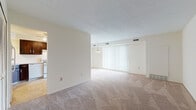 Located at 9333 N Church Dr in Parma Heights, Ohio, this single-floor unit offers a practical and comfortable layout designed for everyday living. The open-concept living and dining area is expansive, featuring neutral-toned carpet, textured ceilings, and large sliding glass doors fitted with vertical blinds that allow generous natural light and provide access to an outdoor balcony with views of surrounding greenery. A pendant light fixture adds a simple decorative touch to the dining portion of the space.

The kitchen is efficiently designed with rich dark wood cabinetry, tile backsplash, and light tile flooring. It is equipped with a gas range, dishwasher, refrigerator, and a sink with ample counter space. A ceiling fan provides ventilation, and a louvered closet door offers additional storage nearby.

The bedrooms are carpeted and feature warm wood doors, built-in closets, and baseboard heating units. One bedroom includes a walk-in closet and an adjacent vanity area, enhancing its functionality. The bathroom is finished with white tile wainscoting, a single-sink vanity with white cabinetry, and light tile flooring, maintaining a clean and classic aesthetic throughout the home.