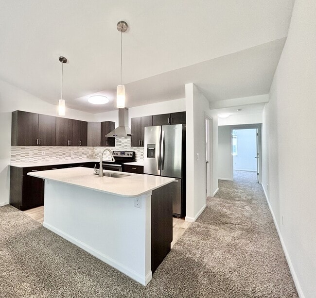 Cocina con isla y encimera de cuarzo - Keystone Lake Apartments