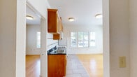Located at 2030 Dwight Way in Berkeley, CA, this one-bedroom, one-bathroom unit offers a thoughtfully designed single-floor layout. Warm hardwood floors flow throughout the main living areas and bedroom, creating a cohesive and inviting atmosphere. Multiple windows fitted with blinds fill the space with natural light and provide views of the surrounding neighborhood streetscape.

The kitchen is well-equipped, featuring rich warm-toned wood cabinetry with brushed nickel hardware, dark countertops with a tile backsplash accented by a mosaic border, and white appliances including a gas range, over-the-range microwave, and refrigerator. Light tile flooring grounds the kitchen area distinctly from the adjacent living space.

The bedroom offers a comfortable footprint with large windows on two walls, maximizing natural light and ventilation. A mirrored sliding-door closet adds both storage and a sense of depth to the room.

The bathroom is clean and functional, featuring light tile flooring, a tub/shower combination, a white vanity with an undermount sink, a large wall mirror, and a small window for natural light and ventilation. The mosaic tile accent border echoes the kitchen's design detail, tying the unit together cohesively.

A hallway connects the rooms efficiently, completing this practical and well-maintained Berkeley residence.