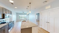 Located at 18237 Tempo Boulevard in Westfield, Indiana, this well-appointed 2-bedroom, 2-bathroom residence offers a thoughtfully designed single-floor layout with clean, modern finishes throughout. Light-toned hardwood-style flooring flows continuously across the entire space, creating a cohesive and bright atmosphere.

The kitchen is a standout feature, showcasing gray shaker-style cabinetry extending to the ceiling for ample storage, granite countertops, a white subway tile backsplash, and a full suite of stainless steel appliances including a refrigerator, range, and microwave. A kitchen island provides additional prep and counter space, while recessed lighting enhances the modern aesthetic.

The open living room benefits from large windows and a glass door that frame picturesque water views, flooding the space with natural light. A ceiling fan adds comfort to the living area.

The spacious primary bedroom features a large window with exterior views, a ceiling fan, and access to a dedicated closet outfitted with wire shelving. The second bedroom is equally well-sized, also includes a ceiling fan, and connects conveniently to its own closet and bathroom.

Both bathrooms are finished with granite-topped dark vanities and light flooring. One bathroom offers a tub-shower combination, while the other provides a walk-in shower. The overall ambiance is fresh, modern, and move-in ready.