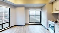 Located at 2346 Weston Rd in Toronto's Weston neighbourhood, this single-floor, one-bedroom, one-bathroom unit offers a efficiently designed layout with modern finishes throughout. Light wood-look laminate flooring runs consistently across all rooms, complemented by crisp white walls, dark baseboards, and recessed lighting that create a clean, contemporary aesthetic.

The unit is accessed through a well-lit hallway lined with white panel doors featuring brushed gold hardware, leading to the various rooms. The bedroom is a comfortable, private space with large windows — including a sliding glass door and a full-height window — that invite natural light and offer views of the surrounding cityscape. Neutral warm-toned walls add a calming atmosphere to the room.

The dining area provides a dedicated space for meals, while the layout is further complemented by two connecting hallways that ensure smooth flow throughout the unit. The full bathroom is neatly appointed with a soaker tub and shower combination, a vanity featuring a granite-topped countertop with under-sink cabinetry, a framed mirror, and overhead lighting. Wood-look flooring extends into the bathroom, maintaining visual cohesion across the entire unit. Overall, the space presents a tidy, move-in-ready environment with practical finishes suited for comfortable urban living.