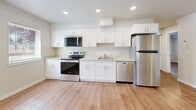 Located at 607 47th St SE in Everett, WA, this ground-floor unit offers a thoughtfully designed 2-bedroom, 2-bathroom layout across a single level. Light wood-tone luxury vinyl flooring runs consistently throughout the space, creating a cohesive and clean aesthetic. The kitchen is a standout feature, showcasing white shaker-style cabinetry, light quartz countertops, recessed lighting, and a full suite of stainless steel appliances including a range, microwave, dishwasher, and refrigerator. Both bedrooms are bright and inviting, each featuring sliding-door closets and windows fitted with blinds that invite natural light while maintaining privacy. The neutral, warm-toned walls complement the light flooring for a calm and versatile ambiance. Both bathrooms continue the modern design language with white vanity cabinetry, quartz-style countertops, and brushed nickel fixtures. The primary bathroom includes an en-suite layout accessible directly from the bedroom corridor. Throughout the unit, clean white trim and recessed lighting add a polished, move-in-ready feel. The overall design is functional, contemporary, and well-suited for comfortable everyday living.