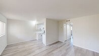 Located at 2811 Central Ave in Fort Myers, Florida, this single-story 2-bedroom, 1-bathroom unit offers a clean, move-in-ready layout with a cohesive neutral design throughout. Light wood-look flooring runs continuously across every room, complementing the crisp white walls and trim to create a bright, airy atmosphere.

The open living area flows naturally toward a combined dining and kitchen space. The galley-style kitchen is well-appointed with white cabinetry featuring black hardware, white countertops, a deep sink with a modern faucet, and black appliances including a refrigerator and electric range. A tray ceiling with flush-mount lighting adds a subtle architectural detail overhead.

Both bedrooms are comfortably sized, bathed in natural light from windows fitted with blinds. The spacious primary bedroom includes direct access to a large walk-in closet with built-in rods and shelving. The unit is notably well-equipped with five closets in total, providing generous storage throughout.

The bathroom is clean and functional, featuring a white vanity with black hardware, an oval mirror, and wood-look flooring that ties into the rest of the home. A hallway connects the private areas of the unit, maintaining a logical and efficient floor plan. The overall ambiance is fresh, light-filled, and understated.