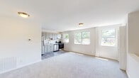 Located at 1007 Ingleside Ave in Catonsville, Maryland, this single-floor unit offers a clean, modern interior with a thoughtfully designed layout. The open-concept living and kitchen area is a central highlight, featuring soft carpeting in the living space that transitions to durable wood-look flooring in the kitchen. Multiple windows line the walls, allowing abundant natural light to pour in and providing pleasant views of the surrounding greenery.

The kitchen is well-equipped with gray shaker-style cabinetry, stainless steel appliances including a refrigerator, electric range, and dishwasher, as well as a single-basin sink. The neutral color palette and clean finishes give the space a contemporary feel.

The bedroom includes plush carpeting, a large window overlooking outdoor greenery, and a generous closet with built-in shelving. The full bathroom features white subway tile surrounding the tub-shower combination, wood-look flooring, a round mirror, and a white vanity with ample storage.

A dedicated utility area houses a stacked washer and dryer alongside the building's mechanical systems, adding everyday convenience. Throughout the unit, neutral tones, bright white walls, and consistent finishes create a cohesive and inviting atmosphere.