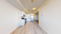 This well-designed 1-bedroom, 1-bathroom unit offers a smart and functional layout that maximizes every square foot of available space. Light-toned hardwood flooring runs throughout the unit, creating a cohesive and bright atmosphere across all rooms.

The open-concept kitchen is a standout feature, equipped with a full suite of stainless steel appliances including a refrigerator, electric range, built-in microwave, and dishwasher. Crisp white cabinetry extends to the ceiling, providing ample storage, while a peninsula-style counter adds workspace and helps define the kitchen area within the open living space.

The bedroom is a cozy, well-proportioned room bathed in natural light from a large corner window that frames views of the surrounding urban landscape. The room includes a sliding closet and connects conveniently to the rest of the unit via a short hallway.

The bathroom features a clean, modern design with light tile flooring, a white vanity with an integrated sink, and a glass-enclosed shower stall with white tile surround. The neutral palette throughout creates a calm and functional space.

Overall, the unit presents a bright, modern, and efficiently organized living space, ideal for individuals or couples seeking a streamlined urban lifestyle.