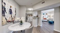 Located at 9955 Buffalo Speedway in Houston, TX, this two-bedroom, three-bathroom residence offers a well-designed single-level layout with a neutral, modern aesthetic throughout. The open-concept kitchen features quartz countertops, white cabinetry, stainless steel appliances including a French door refrigerator and built-in microwave, and a peninsula that connects seamlessly to the dining and living areas. Wood-style plank flooring runs through the main living spaces, adding warmth and continuity. A dedicated laundry area with a full-size washer and dryer is conveniently situated adjacent to the kitchen. The primary bedroom is comfortably scaled, carpeted, and includes a ceiling fan and a window allowing natural light. Its en-suite bathroom features wood-look tile flooring, white vanity cabinetry with quartz countertops, and access to a walk-in closet. An additional full bathroom offers a soaking tub with tiled surround, a single-sink vanity, and its own walk-in closet access. The second bedroom mirrors the primary in comfort, also featuring carpet and natural light. With two closets and three bathrooms, this residence provides ample storage and practicality throughout its thoughtfully utilized floor plan.
