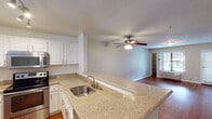 Located at 600 Front Street in San Diego, this single-floor unit offers a thoughtfully designed layout with consistent finishes throughout. The kitchen is a standout feature, equipped with stainless steel appliances including a full-size refrigerator, electric range, and over-the-range microwave. White shaker-style cabinetry provides ample storage, while granite-look countertops extend to a peninsula with an undermount stainless steel sink — ideal for both meal prep and casual dining. Track lighting and a window bring natural light into the kitchen space. Rich hardwood-style flooring flows through the kitchen, living area, and into the bedrooms, providing a warm and cohesive aesthetic. The spacious living area features a ceiling fan with light fixture and connects seamlessly to the rest of the unit. The bedroom includes a mirrored sliding closet and direct access to additional areas of the unit. A door with window blinds provides natural light and potential outdoor access. The bathroom is clean and functional, featuring a granite-look vanity countertop, built-in cabinetry for storage, a medicine cabinet mirror, and hardwood-style flooring. Neutral wall tones throughout the unit create a versatile backdrop suited to a variety of interior styles.