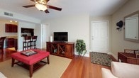 This single-floor residence offers a thoughtfully designed layout that balances comfort and functionality throughout. The living area welcomes with rich hardwood flooring, a ceiling fan, and sliding glass doors fitted with vertical blinds that invite natural light while providing access to the outdoors. A dedicated dining nook, lit by a classic chandelier, provides an intimate setting for meals.

The galley-style kitchen is efficiently arranged with rich mahogany cabinetry, granite countertops, and a full suite of stainless steel appliances, including a range, microwave, refrigerator, and dishwasher. Tile flooring completes the clean, polished look.

The primary bedroom features plush carpeting, a ceiling fan, and direct access to an en-suite bathroom and a walk-in closet. The en-suite bath is finished with granite countertops and dark wood cabinetry. Additional bedrooms are carpeted and offer ceiling fans, ample closet space, and natural light from well-placed windows. A second full bathroom mirrors the design aesthetic with granite countertops and matching cabinetry.

Throughout the residence, a consistent palette of warm neutrals and rich wood tones creates a cohesive and inviting ambiance, making this a comfortable and well-organized living space.