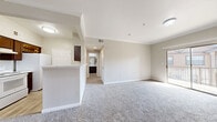 Located at 8100 Huebner Road in San Antonio, Texas, this 2-bedroom, 2-bathroom residence offers a thoughtfully organized single-floor layout designed for comfortable everyday living. The open living room is finished with plush carpeting, crown molding, and neutral warm-toned walls, creating a bright and welcoming atmosphere. A sliding glass door leads to a private balcony, allowing natural light to fill the space and providing pleasant outdoor views. The kitchen features dark espresso cabinetry and is accessible via a breakfast bar that connects it to the main living area. Each bedroom is carpeted and equipped with a ceiling fan, and the primary bedroom includes a spacious closet with double doors. Both bathrooms are finished with light wood-look luxury vinyl flooring, dark vanity cabinetry, white countertops, and large mirrors with bright vanity lighting above. The secondary bathroom includes a full tub-shower combination and a walk-in closet adjacent to the bath. Two hallways provide convenient connectivity throughout the unit, while multiple closets offer ample storage. The consistent neutral color palette and clean finishes throughout give the residence a cohesive, move-in-ready appeal.