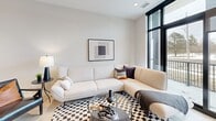 Located at 30 Queensland Road in Stratford, Ontario, this contemporary one-bedroom, two-bathroom unit offers a thoughtfully designed open-concept layout with clean, modern finishes throughout. Light hardwood-style flooring flows seamlessly across the main living areas, complementing the neutral palette of white and warm beige tones.

The kitchen is a standout feature, showcasing tall white upper cabinetry, warm wood-toned lower cabinets, stainless steel appliances, and an extended island with bar seating — ideal for casual dining or entertaining. The adjoining dining and living areas are bright and airy, anchored by large black-framed floor-to-ceiling windows and a sliding door that opens onto a private balcony overlooking the surrounding neighbourhood.

The living room offers a comfortable, modern atmosphere with ample natural light. The spacious primary bedroom continues the minimalist aesthetic with a large black-framed window and recessed lighting. Two well-appointed bathrooms include a full tub-shower combination with white subway tile surround. In-suite stacked laundry adds everyday convenience.

The unit also features a dedicated workspace with tall windows, making it functional for remote work. Throughout, recessed lighting, clean lines, and contemporary design details create a cohesive, refined living environment.