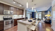 Located at 910 Deerfield Crossing Dr in Alpharetta, GA, this one-bedroom, one-bathroom residence offers a well-designed single-level layout that maximizes both comfort and functionality. The open-concept kitchen is a standout feature, boasting rich dark-wood cabinetry, a subway tile backsplash, stainless steel appliances, and a large granite-topped island with bar seating illuminated by elegant pendant lighting — ideal for both cooking and casual dining. Hardwood floors extend from the kitchen into the living room, which is defined by bold blue accent walls, a ceiling fan, and French doors that invite abundant natural light and outdoor views. The bedroom is a calm retreat with plush carpeting, large windows with garden views, a ceiling fan, and direct access to the walk-in closet. The closet provides generous storage with built-in shelving and hanging rods. The bathroom features a granite-topped vanity with dark wood cabinetry, a large mirror, tile flooring, and a shower-tub combination. A hallway connects the living spaces seamlessly, completing this thoughtfully appointed residence in a desirable North Atlanta community.