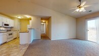Located at 2015 West University Street in Springfield, Missouri, this single-floor unit offers a well-designed, functional layout with a comfortable and practical interior. The open-concept living area is finished with plush carpeting and features a ceiling fan, providing a welcoming space that flows naturally into the kitchen and hallway. A pendant chandelier near the entry adds a decorative touch, while the soaring accent wall lends the living space an airy, generous feel.

The galley-style kitchen is efficiently designed with ample white cabinetry, dark laminate countertops, and tile flooring. It comes equipped with a full suite of white appliances, including a range, over-the-range microwave, refrigerator, and sink, all neatly arranged along opposing walls for easy workflow. A breakfast bar peninsula connects the kitchen to the living area.

Multiple bedrooms are accessible via a central hallway, each finished with soft carpeting, neutral-toned walls, individual ceiling fans, and windows fitted with blinds that allow natural light to filter through. The bathrooms are appointed with tile flooring, white vanity cabinetry, dark countertops, a large mirror, and a tub-shower combination, providing a clean and cohesive aesthetic throughout.
