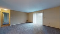 Located at 500 Four Seasons Dr in Mason, Ohio, this single-floor unit offers a straightforward, functional layout across several well-defined living spaces. The living room is generously proportioned, featuring soft wall-to-wall carpeting, warm neutral-toned walls, and a large sliding glass door dressed with vertical blinds that floods the room with natural light and provides access to the outdoors. The entry area transitions seamlessly into the living space, accented by a pendant chandelier that adds a touch of character. The bedroom is a comfortable, carpeted room with a standard window that brings in natural light and outdoor views, complemented by a double-door closet offering practical storage. The kitchen is equipped with an electric range and a dishwasher alongside granite-style countertops, all set on easy-care hard surface flooring. The bathroom is cleanly appointed with a tub-shower combination featuring tiled surround, a toilet, a vanity with a mirror, and an over-the-toilet storage cabinet with white cabinetry. Throughout the unit, the neutral color palette and consistent flooring choices create a cohesive, move-in-ready atmosphere suited for comfortable everyday living in Mason, OH.