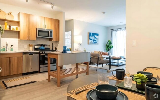 Connected Kitchen and Living Area with Island Cart and Dining Setup - The Madison at Marshfield