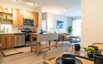 Connected Kitchen and Living Area with Island Cart and Dining Setup - The Madison at Marshfield