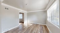 Located at 261 Monroe St in Oswego, Illinois, this two-story home offers a practical and well-organized layout spread across two floors. The main level features a welcoming living room bathed in natural light through a front-facing window, complemented by a decorative oval-glass entry door and crown molding that adds a refined touch. The kitchen is well-appointed with dark cabinetry, granite-style countertops, stainless steel appliances including a gas range and refrigerator, and a double-basin sink. A combined dining room and kitchen area provides convenient everyday functionality. Throughout the home, warm-toned luxury vinyl plank flooring creates a cohesive and low-maintenance aesthetic. The upper level hosts two bedrooms, including a spacious primary bedroom, and a full bathroom. The bathroom features a white vanity with mirrored medicine cabinet, a tub-shower combination, and clean, neutral finishes. Both bedrooms are bright and airy, with ceiling fans, natural light from windows, and ample closet space — the home offers six closets in total. An elegantly railed staircase connects the two floors. The neutral gray palette throughout provides a calm, move-in-ready ambiance suited for a variety of styles.