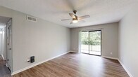 Located at 3205 E Olive Rd in Pensacola, Florida, this 2-bedroom, 2-bathroom residence offers a well-designed single-floor layout with a clean, modern aesthetic throughout. The open living room is finished with wood-look plank flooring, neutral gray walls, and a ceiling fan with light fixture. A sliding glass door leads to a private balcony overlooking lush greenery, filling the space with natural light. The kitchen features a galley-style layout with gray shaker cabinets, white countertops, a subway tile backsplash, stainless steel appliances including a refrigerator, range, microwave, and dishwasher, and a double-basin sink. A pantry provides additional storage. Both bedrooms are carpeted and equipped with ceiling fans and windows that bring in natural light. The spacious primary bedroom offers a comfortable retreat with its own closet. The two bathrooms are finished in crisp white with tub/shower combinations, tile surrounds, and clean modern fixtures. Additional closet space is available throughout the unit. The overall ambiance is bright, neutral, and move-in ready, with consistent finishes that create a cohesive and functional living environment.