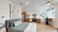 Located at 7800 E Peakview Ave in Centennial, Colorado, this modern studio offers a thoughtfully designed open-concept layout that maximizes every square foot. Light wood-tone flooring runs throughout the main living area, creating a warm and cohesive aesthetic that ties the space together seamlessly.

The kitchen is a standout feature, outfitted with a full suite of stainless steel appliances including a refrigerator, range, microwave, and dishwasher. Two-tone cabinetry pairs warm wood lower cabinets with crisp white upper cabinets, complemented by a geometric hexagonal tile backsplash and clean white countertops. The kitchen flows naturally into the combined living and sleeping area, which benefits from a ceiling fan and a large window that draws in natural light.

The bathroom is clean and contemporary, featuring a walk-in glass-enclosed shower with white subway tile, a wood-toned vanity with a white countertop, and coordinating light wood flooring. A dedicated walk-in closet provides generous storage with wire shelving and hanging rods, finished with plush carpet underfoot.

Recessed lighting throughout the unit enhances the bright, airy ambiance, making this a well-appointed and efficiently designed space in the heart of Centennial.