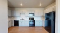 Located at 500 Stoker Ave in Reno, Nevada, this well-designed single-floor, 3-bedroom, 2-bathroom home offers a clean, modern aesthetic throughout. The open kitchen is a standout feature, showcasing crisp white shaker cabinetry, generous counter space with light-toned countertops, and a full suite of black appliances including a range, microwave, dishwasher, and refrigerator. Light wood-style flooring runs through the main living areas, enhancing the bright and airy feel of the space. The living area is complemented by a wall-mounted mini-split system for climate control and access to an outdoor balcony through sliding glass doors, framing views of the surrounding trees and Nevada landscape. The bedrooms are carpeted and bathed in natural light from large windows that offer scenic outdoor views. Each bedroom benefits from dedicated closet space, including a spacious walk-in closet with wire shelving. The two bathrooms are neatly finished with gray cabinetry, white countertops, and a tub-shower combination. A dedicated laundry room adds everyday convenience. With five closets throughout, the home offers abundant storage to complement its functional and comfortable layout.