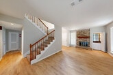 This two-story home in Houston's 77057 zip code offers three bedrooms, four bathrooms, and a well-considered layout spread across two floors. The main level welcomes you with a foyer that opens to a bright living room anchored by a classic brick fireplace with a wood mantel, complemented by light hardwood-style flooring. A sliding glass door in the dining area fills the space with natural light and provides access to the patio. The galley-style kitchen features white cabinetry, wood-tone countertops, stainless steel appliances, and a clean tile backsplash. A dedicated laundry room with upper cabinetry and appliance hookups adds everyday convenience, alongside an attached garage. Upstairs, the bedrooms are finished with plush carpet and ceiling fans. The spacious primary bedroom boasts dramatic vaulted ceilings with exposed beams, a walk-in closet, and an en-suite bathroom. Additional bedrooms are generously sized with ample closet space and easy access to well-appointed bathrooms featuring tiled tub-shower combinations. Five closets throughout the home ensure abundant storage. The layout is practical and functional, making this a comfortable residence in a central Houston location.