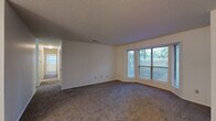 Located at 2401 Lakeview Rd in North Little Rock, AR, this single-story, 2-bedroom, 2-bathroom home offers a practical and comfortable layout across one level. The living room is generously proportioned, featuring plush wall-to-wall carpeting, neutral white walls, a textured ceiling, and a large multi-pane window that fills the space with natural light and frames views of the surrounding greenery. The living area flows openly into a dedicated dining room, accented by a classic chandelier overhead. The kitchen is equipped with wood-toned cabinetry, white appliances, and recessed lighting, with an adjacent laundry and utility room adding everyday convenience. Both bedrooms are carpeted and well-sized, each with windows that bring in natural light. The primary bedroom offers a notably spacious footprint, while both rooms are served by generous closet storage — with six closets total throughout the home. The two full bathrooms each feature a tub/shower combination with built-in shelving, wood-look flooring, and clean, bright finishes. A connecting hallway ties the layout together efficiently. The textured ceilings, neutral color palette, and abundant storage make this a functional and move-in ready home.