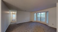 Located at 2401 Lakeview Rd in North Little Rock, AR, this single-story, 2-bedroom, 2-bathroom home offers a practical and comfortable layout across one level. The living room is generously proportioned, featuring plush wall-to-wall carpeting, neutral white walls, a textured ceiling, and a large multi-pane window that fills the space with natural light and frames views of the surrounding greenery. The living area flows openly into a dedicated dining room, accented by a classic chandelier overhead. The kitchen is equipped with wood-toned cabinetry, white appliances, and recessed lighting, with an adjacent laundry and utility room adding everyday convenience. Both bedrooms are carpeted and well-sized, each with windows that bring in natural light. The primary bedroom offers a notably spacious footprint, while both rooms are served by generous closet storage — with six closets total throughout the home. The two full bathrooms each feature a tub/shower combination with built-in shelving, wood-look flooring, and clean, bright finishes. A connecting hallway ties the layout together efficiently. The textured ceilings, neutral color palette, and abundant storage make this a functional and move-in ready home.