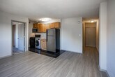Located at 414 N Forest Park Blvd in Knoxville, Tennessee, this single-floor unit offers a practical and well-organized layout suited for comfortable everyday living. The open living area features light-toned hardwood-style flooring that extends toward the kitchen, creating a cohesive and airy feel throughout the main space. Windows allow natural light to filter in, with views of surrounding greenery and neighboring homes, enhancing the bright and welcoming atmosphere.

The kitchen is efficiently designed with warm wood-toned cabinetry, dark tile flooring, and stainless steel appliances including a refrigerator, gas range, and over-the-range microwave. A washer unit is conveniently integrated within the kitchen area, adding functional value to the space.

The bedroom features plush carpeting underfoot and a window with a view of the tree-lined surroundings, contributing to a calm and restful environment. A closet with built-in shelving and a hanging rod provides ample storage and organization options.

The bathroom is clean and straightforward, featuring a full tub-and-shower combination with white tile surround, chrome fixtures, and open shelving nearby for toiletries and linens. Textured ceilings are present throughout, adding a subtle layer of visual character to each room. Overall, the space offers a functional and comfortable living environment in a convenient Knoxville location.