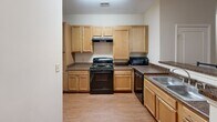 Located at 342 Walden Station Dr in Charlotte, NC, this single-floor unit offers three bedrooms and three full bathrooms within a well-organized and functional layout. The open-concept living and dining area serves as the heart of the home, featuring warm hardwood-style flooring, a ceiling fan, and a private exterior door that brings in natural light. A wall-mounted TV and comfortable seating make the living space ideal for relaxing or entertaining. The dining area accommodates a full-sized table, seamlessly connecting to the kitchen. The kitchen is well-appointed with light maple cabinetry, dark granite-style countertops, black appliances including a range, dishwasher, and microwave, plus a double sink — providing ample functionality for everyday cooking. Each of the three bedrooms offers hardwood-style flooring, neutral warm-toned walls, and windows with natural views, creating a calm and comfortable atmosphere. The bedrooms are versatile, accommodating both sleeping and study needs. The three full bathrooms each feature a clean white tub-shower combo with brushed nickel fixtures and tile flooring, maintaining a consistent, practical aesthetic throughout. The unit's neutral color palette and cohesive design provide a move-in-ready foundation.