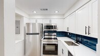 Located at 8216 Frankford Ave in Philadelphia's 19136 neighborhood, this thoughtfully renovated single-floor space offers a clean, modern aesthetic with functional design throughout. The kitchen is a standout feature, showcasing crisp white shaker cabinets with matte black hardware, gleaming white quartz countertops, and a striking deep-blue subway tile backsplash that adds a bold contrast. A full suite of stainless steel appliances — including a refrigerator, electric range, over-the-range microwave, dishwasher, and undermount sink with a black faucet — makes this kitchen both stylish and highly functional. Light hardwood-style flooring runs throughout the space, contributing to a warm, cohesive feel. The living and sleeping areas are bright and open, with recessed lighting and windows that allow natural light to filter in. A generously sized bedroom includes a double sliding-door closet, offering ample storage. The bathroom continues the modern design language with bold teal subway tile. Clean white walls, updated fixtures, and consistent finishes across every room give this space a polished, move-in-ready character that is both practical and visually appealing.