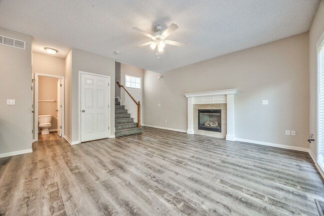 Living room with fireplace and ceiling fan - 22810 West 71st Terrace