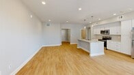 This well-appointed one-bedroom, one-bathroom residence in Farmington, CT offers a thoughtfully designed open-concept layout with modern finishes throughout. Light hardwood-style flooring flows seamlessly through the living areas, creating a warm and cohesive feel. The kitchen is a standout feature, boasting white shaker cabinetry, granite countertops, a subway tile backsplash, stainless steel appliances, and a central island with a sink and elegant pendant lighting — ideal for both cooking and casual dining. The kitchen opens directly into the spacious living room, which benefits from natural light streaming through large windows with outdoor views of the surrounding greenery. The generous primary bedroom features recessed lighting, ample space, and direct access to a large walk-in closet outfitted with full wire shelving systems for maximum storage and organization. The bathroom is finished with marble-style tile flooring, a dark espresso vanity with a white countertop, a framed mirror, and a tub-shower combination. Recessed lighting and neutral gray tones throughout lend the entire space a clean, contemporary ambiance. A dedicated entrance completes this well-rounded residence.