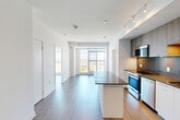 Located at 40 Lagerfeld Drive in Brampton, Ontario, this modern 2-bedroom, 2-bathroom unit offers a well-designed open-concept layout with contemporary finishes throughout. The living and dining area flows seamlessly from the kitchen, anchored by large floor-to-ceiling windows at the far end that frame sweeping elevated views of the surrounding Brampton cityscape and transit corridor below, filling the space with abundant natural light. Durable wood-tone laminate flooring runs throughout the unit, complementing the clean white walls and modern aesthetic.

The kitchen is a standout feature, equipped with a central island topped with a dark stone countertop, two-tone cabinetry combining warm wood uppers and crisp white lowers, a grey tile backsplash, stainless steel appliances including a gas range, built-in microwave, dishwasher, and refrigerator, all illuminated by track lighting overhead.

The two bedrooms are bright and airy, each with large windows offering open views. The two bathrooms are finished in clean white tile — one featuring a glass-enclosed walk-in shower, the other a full soaker tub with overhead shower. The unit's efficient layout and elevated position make it a highly functional and light-filled urban residence.