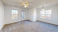 Located at 300 E Peachtree Dr in Nixa, MO, this single-story, one-bedroom, two-bathroom unit offers a practical and well-organized layout across a compact but efficiently designed floor plan. The living room is bright and welcoming, featuring plush carpeting, a ceiling fan, textured ceilings, and multiple windows that bring in generous natural light. A door from the living area provides direct outdoor access, adding convenience and connectivity to the exterior. The space flows through hallways that connect the main living areas to the private quarters. The galley-style kitchen is outfitted with light wood cabinetry, bold red countertops, tile flooring, and white appliances including a refrigerator, stove, and built-in microwave. A window above the sink allows natural light into the workspace. The bedroom is a comfortable size, fitted with carpet, a ceiling fan, and a window with outdoor views. Multiple closets throughout the unit provide ample storage. The bathrooms feature tile flooring, with one offering a vanity with wood cabinetry, a large mirror, and a separate toilet area. A dedicated laundry area and utility room round out the functional offerings of this well-appointed single-floor residence.
