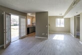 Located at 1660 Kendall Dr in San Bernardino, California, this single-story residence offers a well-organized layout designed for comfortable everyday living. The open living and dining area is finished with light wood-look tile flooring that runs throughout most of the unit, complemented by neutral taupe walls and a textured ceiling. Natural light filters in through multiple windows, and a glass sliding door leads directly to an outdoor area, enhancing the sense of openness. The kitchen is thoughtfully equipped with two-tone cabinetry — white upper cabinets and gray lower cabinets — along with laminate countertops, a double sink, and black appliances including a full-size refrigerator and gas range. The bedrooms are generously sized, each featuring the same wood-look tile flooring, textured ceilings, and sliding closet doors, with one bedroom offering mirrored closet doors for added functionality. Both bathrooms are finished consistently, showcasing gray vanity cabinets, granite-style countertops, a single sink, a large mirror, and a shower-tub combination. Clean white walls and wood-look tile flooring carry through these spaces as well. Overall, the unit presents a cohesive, move-in-ready aesthetic with practical finishes throughout.